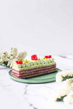 Yeşil kremalı, kirazlı ve şam fıstıklı mermer kaplamalı pasta tatlısı.