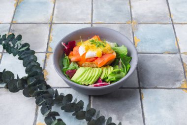 Lezzetli kahvaltı, brunch haşlanmış yumurta, somon, avokado, fayanslı roka salatası.