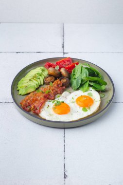 Yumurta, avokado, peynir ve pastırmalı sağlıklı keto kahvaltısı.