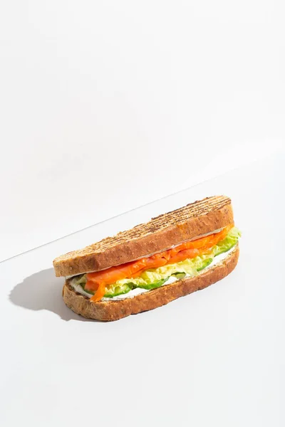 Sandwich with salmon, cheese and salad on grey dark shadow — Stockfoto