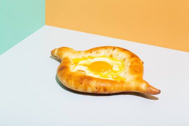 Kafkas düz ekmekleri, turuncu arka planda yumurtalı ekmekçi Khachapuri.