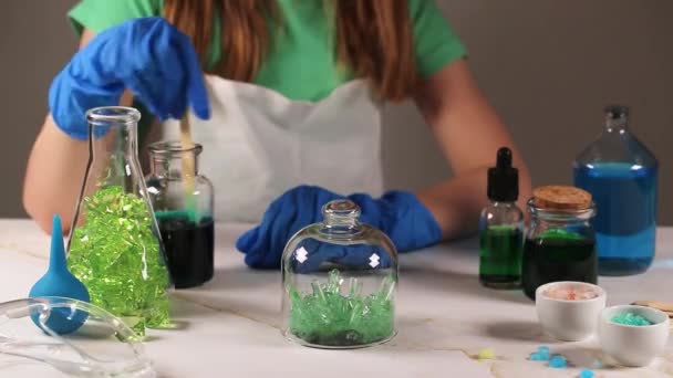 Lapsen kasvattama vihreä kristalli. Sekoitan. Tiede on hauska käsite. Lasten kokeilu kotona. — kuvapankkivideo