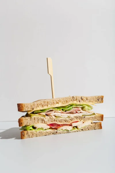 Triángulos sándwich de pan integral de tomate y ensalada de pollo sobre minimalismo gris Imagen De Stock