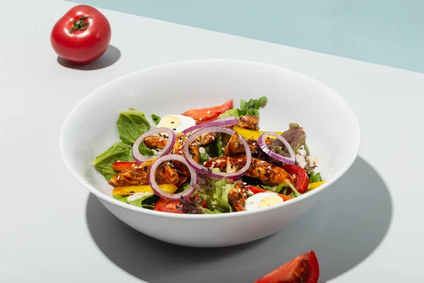 Sallad med grillad ål och grönsaker tomater lök ägg hårda skuggor moderna Stockfoto