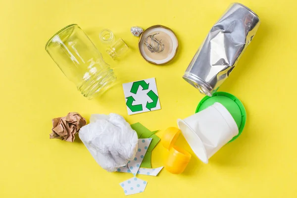 Geri dönüşüm için temiz çöp - metal, plastik kağıt ve cam. Sarı üzerinde geri dönüşüm kavramı. — Stok fotoğraf
