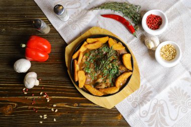 Kızartma tavasında, kızarmış patates dilimleri sos, çatal bıçak takımı, kırmızı dolma biber, şampiyonlar, sos, acı biber, baharatlar, biberiye dalı masada..