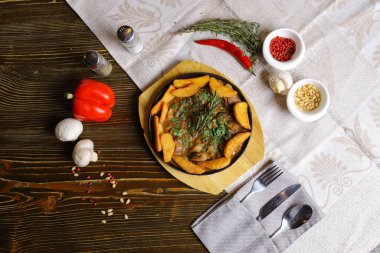 Kızartma tavasında, kızarmış patates dilimleri sos, çatal bıçak takımı, kırmızı dolma biber, şampiyonlar, sos, acı biber, baharatlar, biberiye dalı masada..