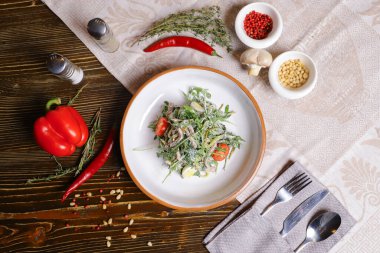 Roka yapraklı salata, haşlanmış dil soslu uzun dilimler halinde kesilmiş. Bir çift tuz ve biber, çatal bıçak takımı, kırmızı biber masayı süsleyin..