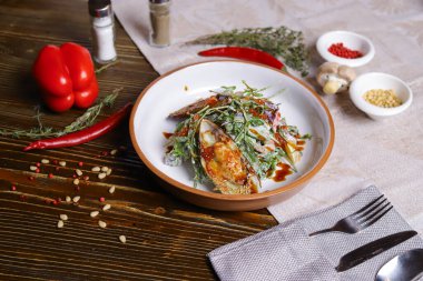 Midyeli salata, roka, kırmızı havyar, yuvarlak tabakta karides çatal bıçak takımı, biber-tuz buharı, bütün kırmızı biber, acı biber, süs olarak baharat. Koyu ahşap bir masanın üzerindeki keten peçete..