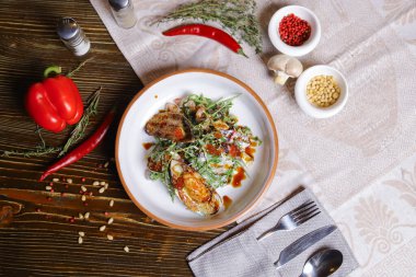 Midyeli salata, roka, kırmızı havyar, yuvarlak tabakta karides çatal bıçak takımı, biber-tuz buharı, bütün kırmızı biber, acı biber, süs olarak baharat. Koyu ahşap bir masanın üzerindeki keten peçete..