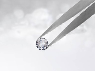 Beyaz parlak bokeh arka planında cımbızla parlayan elmas. En iyi elmas mücevher tasarımı konsepti