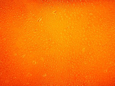 Turuncu arkaplan dokusuna su damlaları. arkaplan camı su damlalarıyla kaplı.