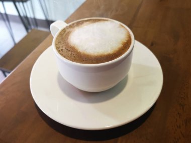 tablo üzerinde beyaz bir fincan sıcak kahve