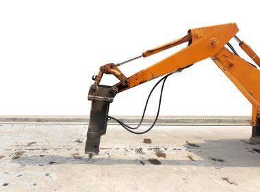 Kazıcı tamir için beton yolu kırıyor ve deliyor. İnşaat malzemelerinin hidrolik koluna monte edilmiş büyük bir pnömatik çekiç. Yol onarım araçları. Delinen matkap.