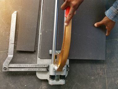 İnşaat işçisi evde fayans kesiyor.