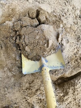  Kürek inşaat işi için kum yığınına konmuş. Kum toplamak için kullanılır.