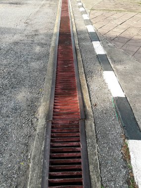 Su kanalizasyonu ya da yolda bir hendek. Oluklar ızgara ızgarası, kanalizasyon kapağı. Yol giderleri - kanalizasyon kapağı. Her şehirde yoldaki su kanallarının demir ızgarası. Su, yoldaki drenaja gider.