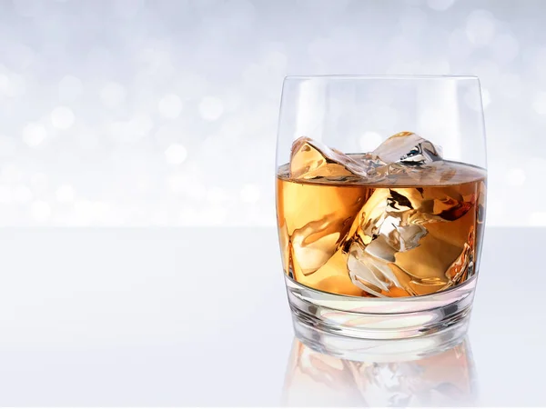 Whiskey with ice in a glass on white shining bokeh background. 3d render