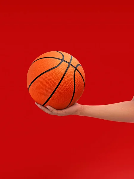 Hands and basketball isolated on red background
