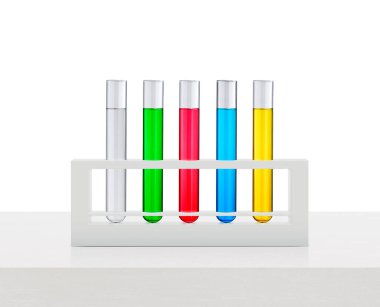 Tüplerdeki renkli sıvılar beyaz ahşap masada.