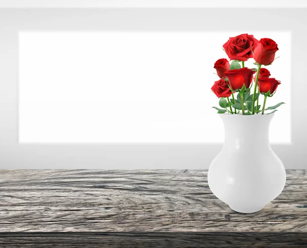 Red rose flowers in vase on wooden table with copy space