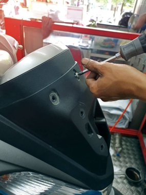 Bisiklet tamiri. Garajda motosiklet tamir eden genç bir adam. Motosiklet tamircisi. Bisiklet tamirhanesinde motosikletini tamir eden ciddi bir genç adam.