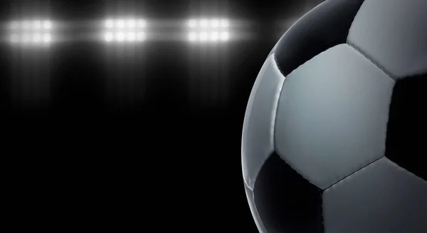 Football on a black background under stadium lights