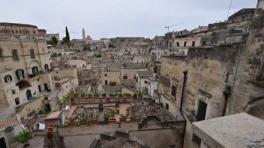 Matera, Basilicata, İtalya. Ağustos 2021. Piazza Vittorio Veneto 'nun balkonundan Matera' nın Sassi 'sine doğru geniş açılı mercekli kamera görüntüleri. Köydeki eski evlerin düzenlenmesi..
