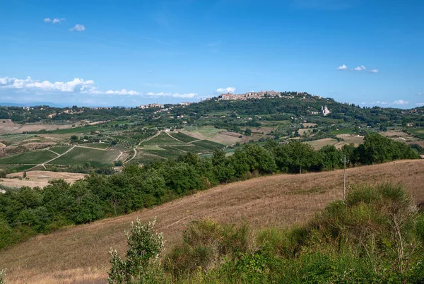 Montepulciano, Toskana, İtalya. Ağustos 2020. Tepenin tepesinde tarihi Montepulciano köyü olan Toskana kırsalının muhteşem manzarası. Güzel bir yaz günü.