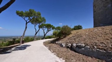 Andria, Puglia, İtalya. Ağustos 2021. POV görüntüleri Castel del Monte 'de dolaşıyor. Sağda, kalenin heybetli duvarları solda Murgia parkının muhteşem manzarası..