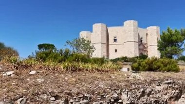 Andria, Puglia, İtalya. Ağustos 2021. POV görüntüleri Castel del Monte 'ye giden yolda yürüyor. Gökyüzü açık, muhteşem bir yaz gününde, kale sahnenin hakimi..