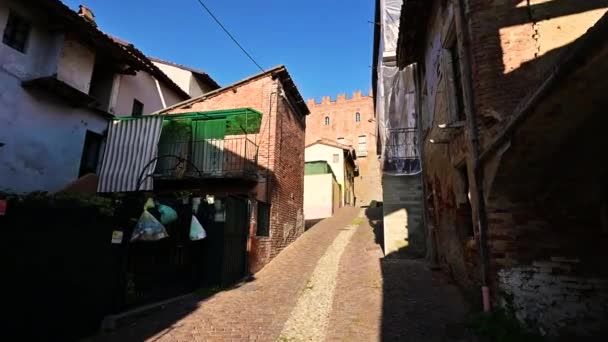 モンテマグノ ピエモンテ イタリア 丘の上の城につながる路地の一つに沿って歩いてPov映像 私たちの横には 村の家の流れ — ストック動画