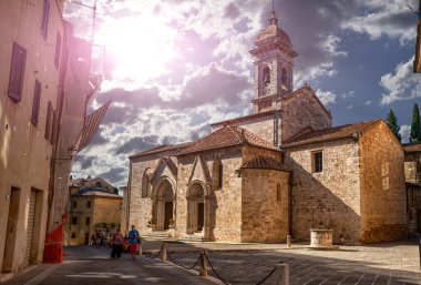 San Quirico d 'Orcia, Toskana, İtalya. Ağustos 2020. San Quirico d 'Orcia Koleji Kilisesi. Arka planda Coronavirus maskeli turistler var..