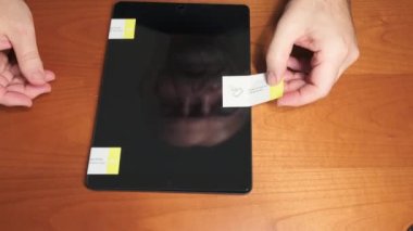 Torino, Piedmont, İtalya. Kasım 2021. Yeni bir tablet ekranına koruyucu cam takıyorum. Onu monte eden teknisyenin yansıyan yüzünü tanıdınız mı?.