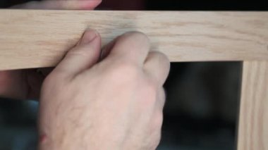 Ahşap bir sandalyenin setteki parçalarının yakın çekim görüntüleri. Eller deliğe bir vida sokup vidala, Allen tuşuyla iyice sık..