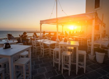 Gelibolu, Puglia, İtalya. Ağustos 2021. Gün batımının inanılmaz atmosferi aperatifi büyülü hale getirir. İnsanlar eğlenmek için barlara ve restoranlara akın ediyor..