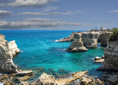 Melendugno, Lecce ili, Puglia, İtalya. Ağustos 2021. Sant 'Andrea' nın yığınları doğal bir ilgi odağı: İnanılmaz manzara tropikal bir yer olduğunu gösteriyor. İnsanlar banyo yapıyor..