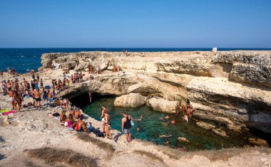 Roca Vecchia, Melendugno, Puglia İtalya. Ağustos 2021. Grotta della Poesia 'nın görüntüsü, açık denize bağlı inanılmaz bir doğal havuz. İnsanlar dalarak cennetin tadını çıkarıyorlar..