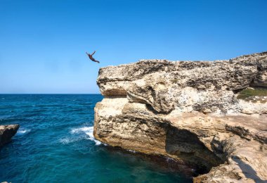 Roca Vecchia, Melendugno, Puglia İtalya. Ağustos 2021. Grotta della Poesia 'nın görüntüsü, açık denize bağlı inanılmaz bir doğal havuz. İnsanlar dalarak cennetin tadını çıkarıyorlar. Bir adam yüzer..