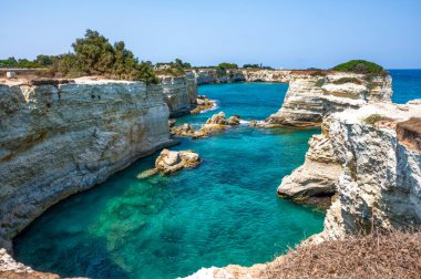 Melendugno, Lecce ili, Puglia, İtalya. Ağustos 2021. Sant 'Andrea' nın yığınları doğal bir ilgi odağı: İnanılmaz manzara tropikal bir yer olduğunu gösteriyor. İnsanlar banyo yapıyor..