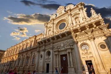 Lecce, Puglia, İtalya. Ağustos 2021. Santa Croce Kilisesi Lecce Barok 'un en iyi örneğidir. Manzara tüm güzelliğini öğleden sonra ışıklarıyla sergiliyor. İnsanlar.
