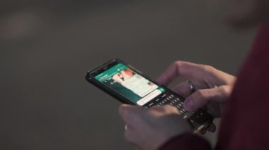 Torino, Piedmont, İtalya. Şubat 2022. Orta yaşlı, beyaz bir kadının elleri mesajlaşırken cep telefonu ekranında yakın çekim görüntüleri var. Bulanık arkaplan.