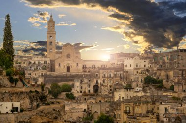 Matera, Basilicata, İtalya. Ağustos 2021. Altın saatinde katedralin ön cephesi. Matera taşlarının tipik evlerinin etrafında.