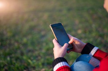 Genç bir kadının parmakları mesaj yazarken akıllı telefon ekranında yakın çekim. Boşluğu kopyala.