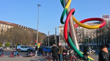 Milan, İtalya, Mart 2022. Modern sanat eserlerinin eğik görüntüleri bir iğneyi çok renkli bir iplikle temsil ediyor: kırmızı, yeşil ve sarı. Yoldan geçenler.