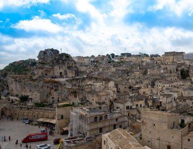 Matera, Basilicata, İtalya. Ağustos 2021. Soldaki Santa Maria di Idris 'in taş kilisesiyle göz kamaştırıcı bir manzara. Taşlardan oluşan şehir manzarası.