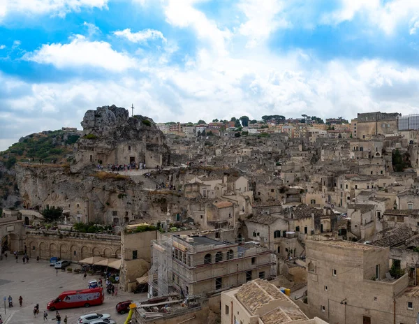 Matera, Basilicata, İtalya. Ağustos 2021. Soldaki Santa Maria di Idris 'in taş kilisesiyle göz kamaştırıcı bir manzara. Taşlardan oluşan şehir manzarası.
