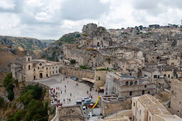 Matera, Basilicata, İtalya. Ağustos 2021. Soldaki San Pietro Caveoso Kilisesi ve sağdaki Santa Maria di Idris Rock Kilisesi 'nin muhteşem manzarası. Taşlardan oluşan şehir manzarası.