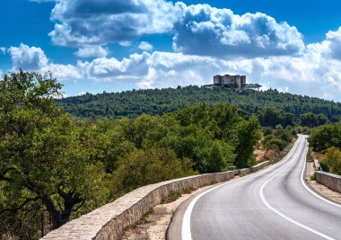 Beyaz bulutlu mavi gökyüzüne karşı Castel del Monte. Kutsal Roma İmparatoru 2. Frederick tarafından 13. yüzyılda İtalya 'nın Puglia kentinde sekizgen şeklinde inşa edilmiş inanılmaz bir kale..