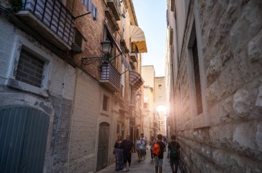 Bari, Puglia, İtalya. Ağustos 2021. Tarihi merkezin sokaklarındaki turistler, Bari Vecchia, büyüleyici manzaralar ve cazibeyle doludur. Paved caddesi ve sokaktaki evler.